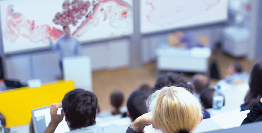 Students in the lecture hall watch a live microscope view with the help of PathoZoom Scan and LiveView